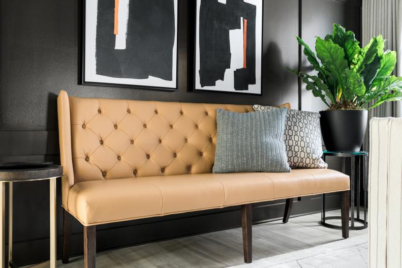 Warm honey-brown leather mixed with modern side tables and brass accents brings in warmth and light to contrast the charcoal-brown walls. Blending a range of contrasting tones is a smart way to tie the design of the room together without feeling overwhelming.
