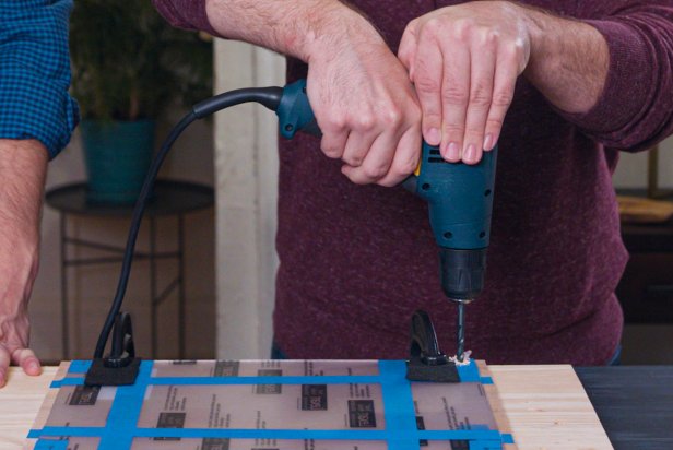 Using a drill, make holes through both the acrylic and wood at each defined pencil mark. Be sure to hold the drill firmly and press straight down. Adjust the clamps as needed.