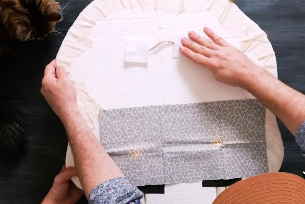 Last, cut a piece of twine and two small squares of felt. On the back of the skull, generously add hot glue from a low temp hot glue gun to the ends of the twine to keep in place. Cover the ends with the felt squares and press down until dry.