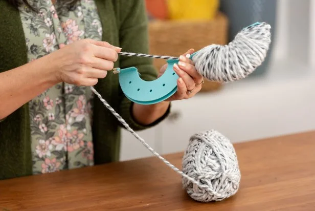 When one side of the pom-pom maker is very full, switch to wrapping on the other side, but do not cut the yarn. Use half the skein on one side, and half the skein on the other.