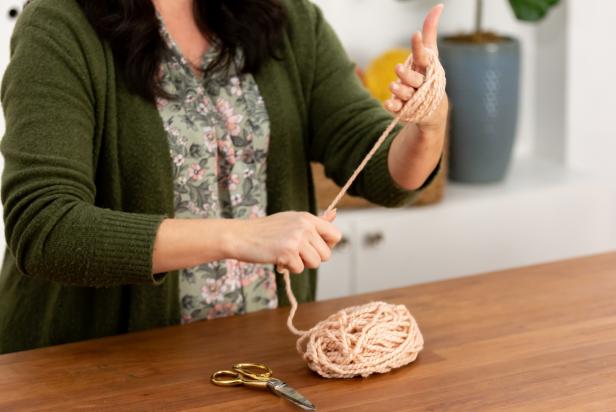 The simplest way to make a bigger pom-pom is to use your hand. Take the loose end of the yarn from the skein and begin by wrapping it around the widest part of your hand. Wrap approximately 50 times.
