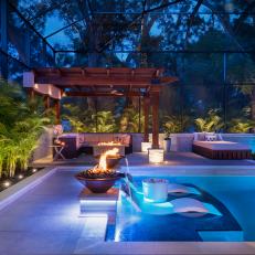Pool With Fire Bowls and Patio at Night