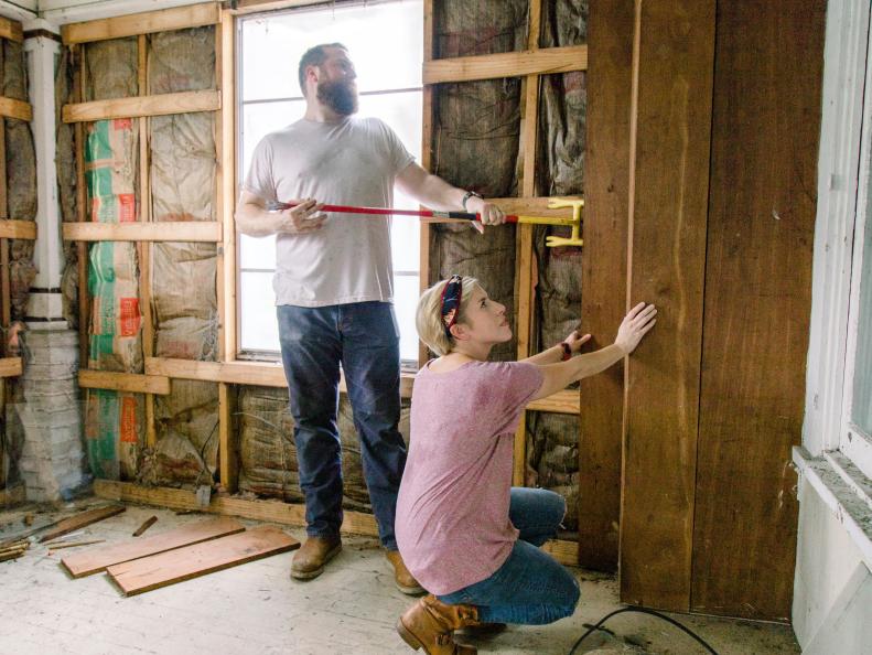 As seen on Home Town, Ben and Erin Napier work together to tear down the paneling of a wall in the Yeager house, which will be completely renovated.