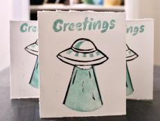 Greeting Card That Says "Greetings" With an Alien Flying Saucer