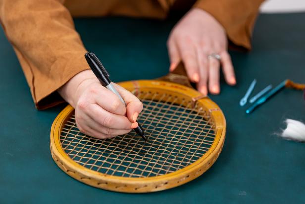 Using a permanent marker, mark the center points of your design on the tennis racket. The yarn will cover up the markings.