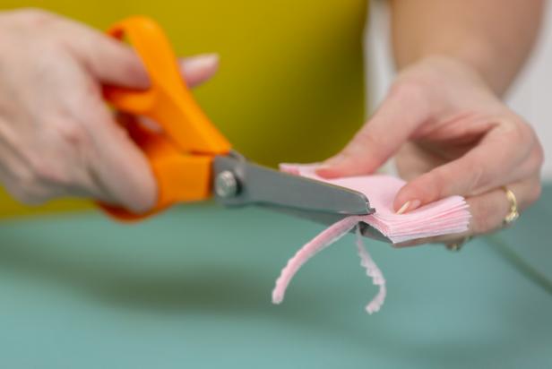 Using pinking shears, cut one side of the paper to make a zig-zag edge.