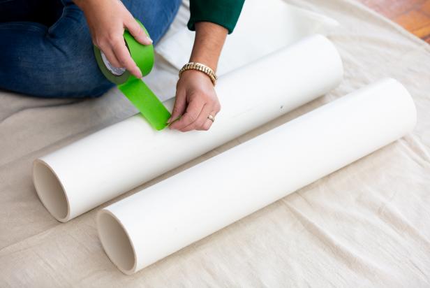 Painter's tape is used to mask lines for painting PVC pipes for a DIY nutcracker Christmas decoration.