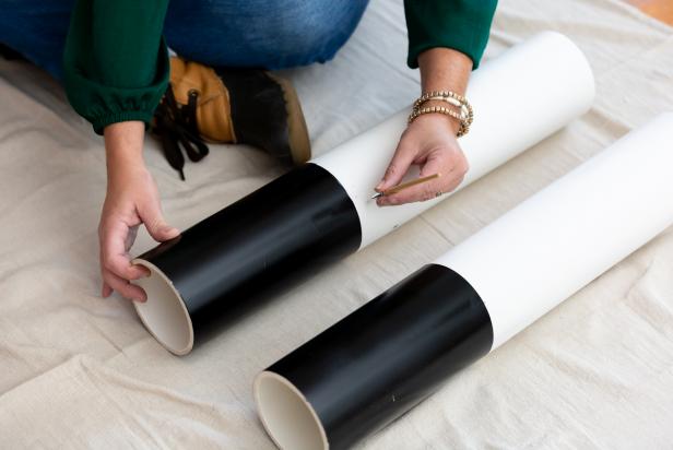PVC pipes are being painted with black paint and decoupage glue to create a giant, life-sized nutcracker.