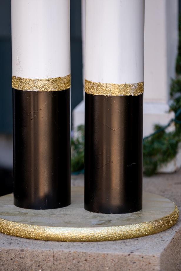 These PVC pipes have been painted with black and gold paint as well as decoupage glue and glitter to resemble giant nutcracker legs.