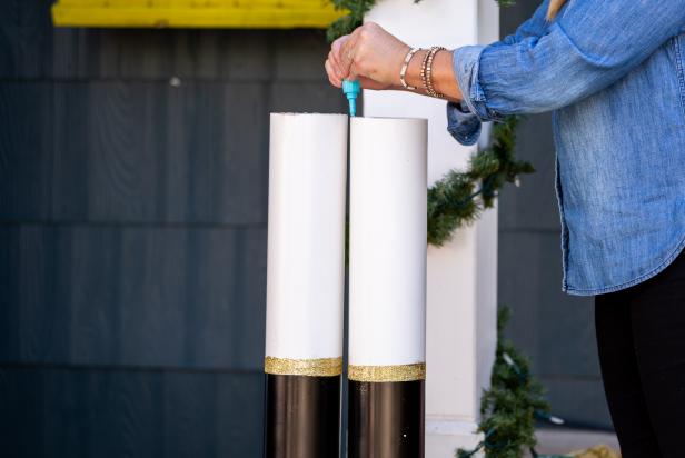 Glue is used to attach a life-sized nutcracker body to large legs made from PVC pipes.