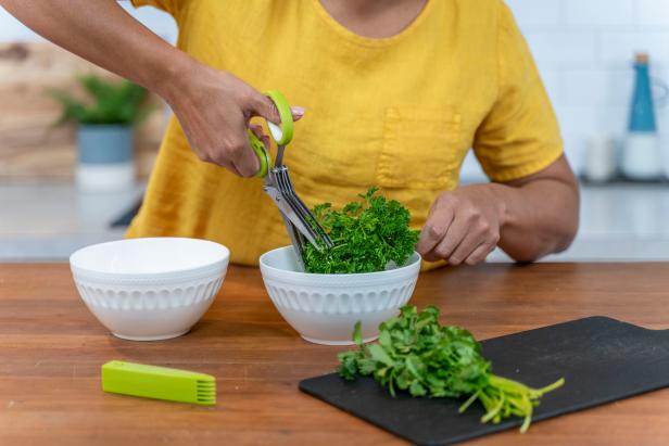 Woman Cutting Cilantro in Bowl With Scissors That Have Five Blades