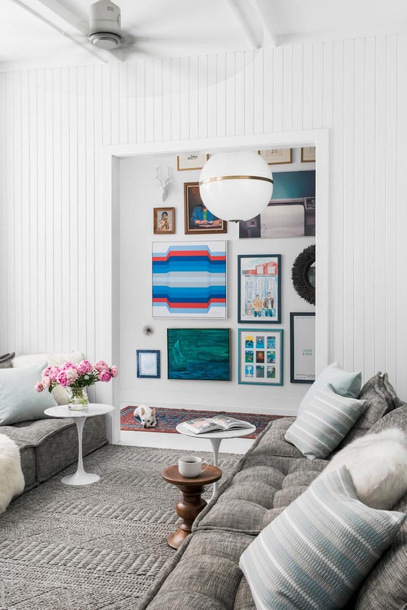 This is the most used spot in the house. To make it feel even taller and more open and airy, Brian accentuate the height with bare white paneled walls inside the lounge, and with a technicolor floor to ceiling art gallery installation in the adjacent entry way.