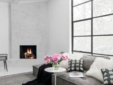 White paneled walls, a 15-foot steel and glass window and a corner fireplace covered in cement create an understated, relaxing spot to sit and take a load off.