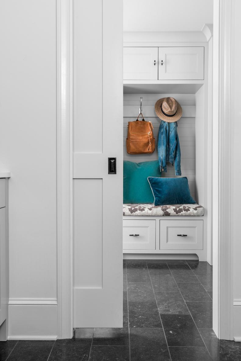 When adjacent rooms open up to one another, it's smart to consider how seamless you can make them so they appear larger and with proper flow. Both the laundry room and the mudroom are outfitted in muted shades of grey and separated by a pocket door which can help keep the sounds of the washer and dryer muffled from other areas of the home.