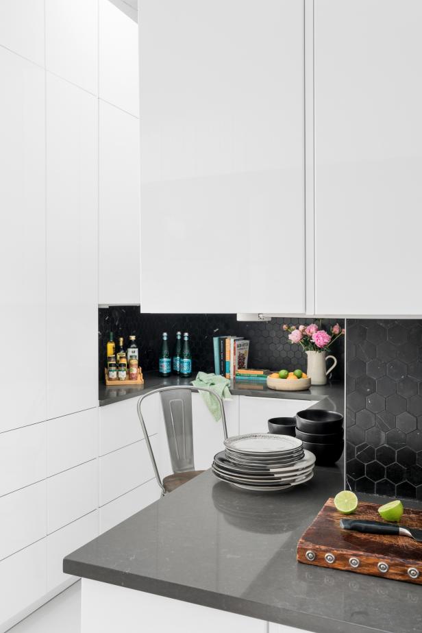 Nearly every surface in this butler's pantry is bright white, a huge help in keeping the space feel extra open and cheerful. For contrast, the countertops are a dark charcoal soapstone and the backsplash tile is black marble mosaic in a midcentury modern hexagon pattern.