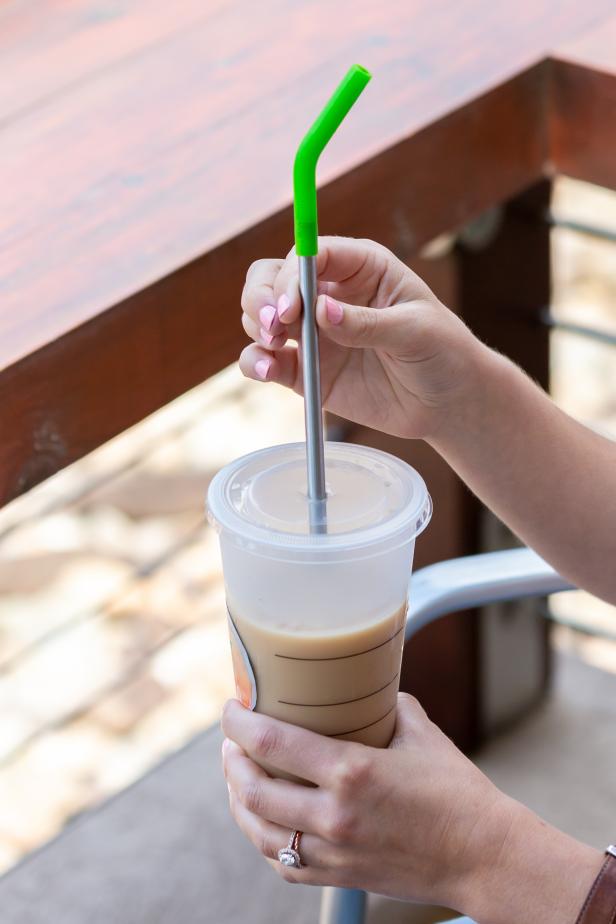 placing a reusable straw in a to-go coffee