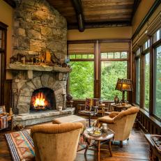 Rustic Formal Living Room in Mountain Home With Tall Stone Fireplace and Tons of Natural Light