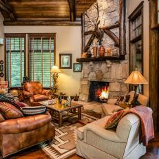 Formal Living Room With Towering Fireplace and Exposed Beams Throughout