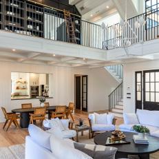 Open-Concept Living and Dining Space With Sitting Area in Loft Featuring Black Built-Ins