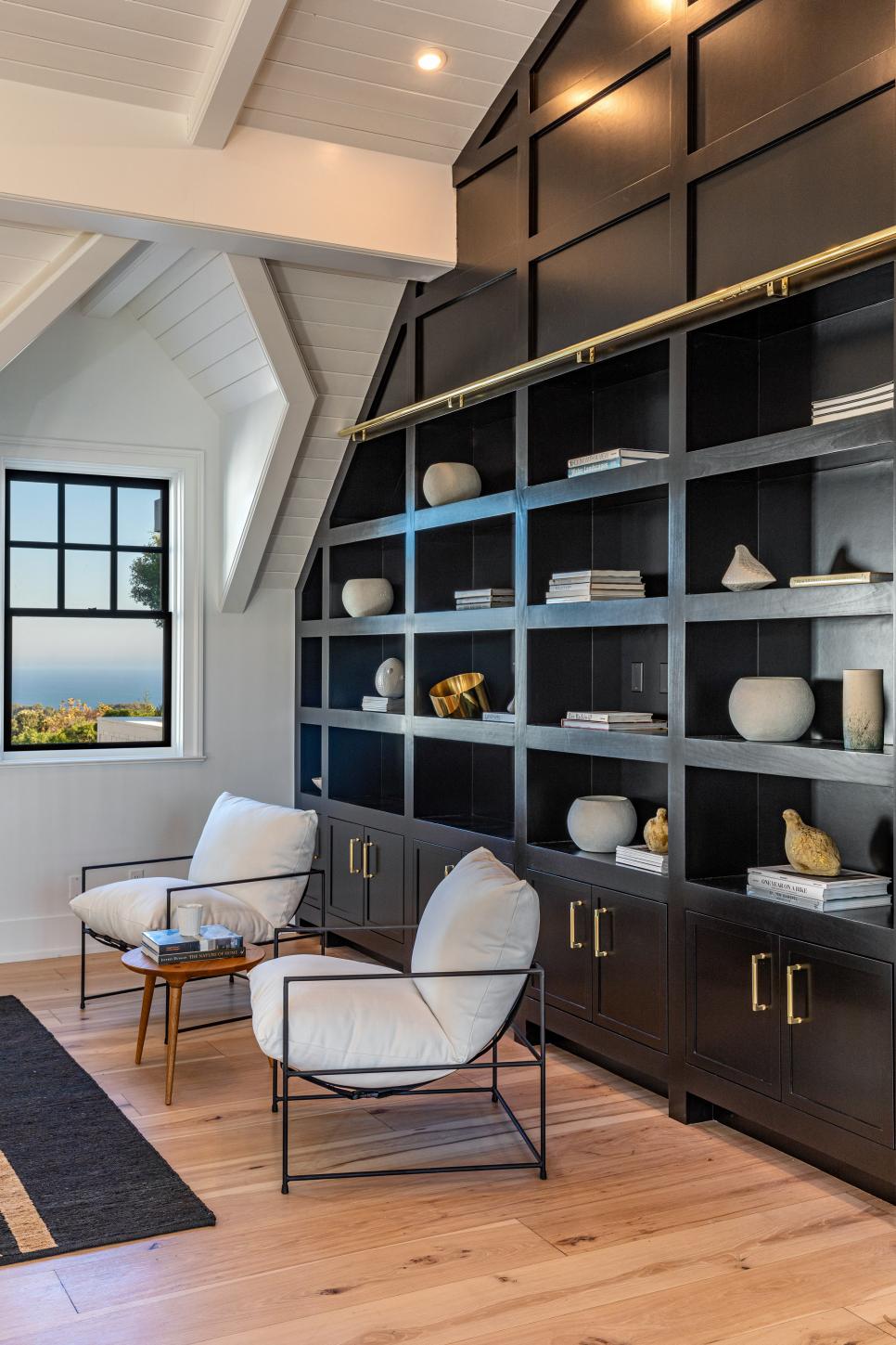 Bold Black Built-In Cabinets Sitting Behind Two Modern Chairs | HGTV