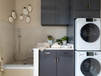 Neutral Laundry Room Has Stacked Appliances and Blue-Gray Cabinets