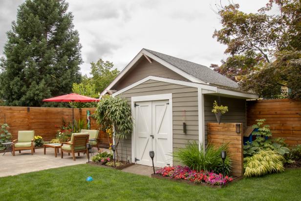 Repeating design elements, like the wooden wall attached to this shed that matches the one surrounding the yard, makes a shed fit into the landscape. Planting beds next to the shed makes it look like part of the garden.