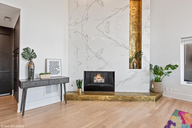 Marble Floor-To-Ceiling Fireplace in Living Room With Gold-Toned Niche