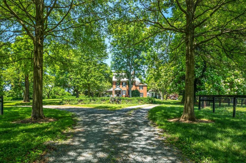 Tree-Lined Circle Driveway Leads to Historic Brick Manor House In View