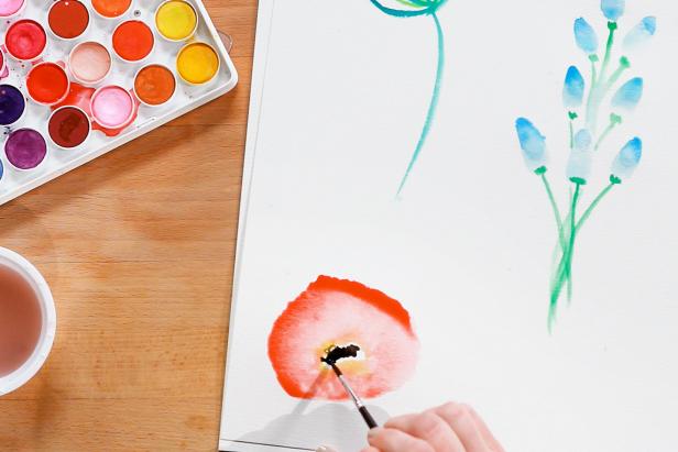 Blend yellow paint into the red and add dots of black paint in the center to finish your poppy.