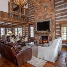 Formal Living Room With Massive Stone Fireplace Set Against Log Cabin Walls
