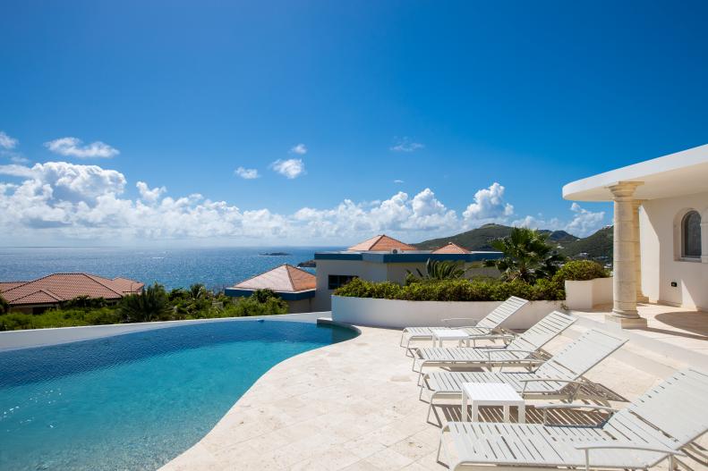 Hilltop Villa's Outdoor Patio With Infinity Pool and Lounge Chairs