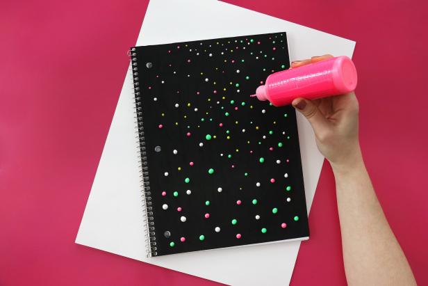 Use puffy paint to add dots all over the notebook cover. Feel free to use as many colors as you like and make any design you want.