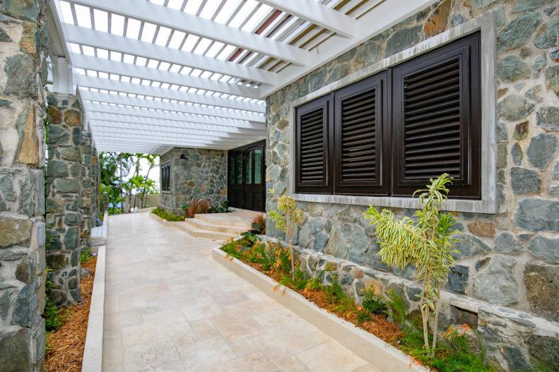 Rock Siding on Villa Exterior With Pergola At Entrance, Tile Floors