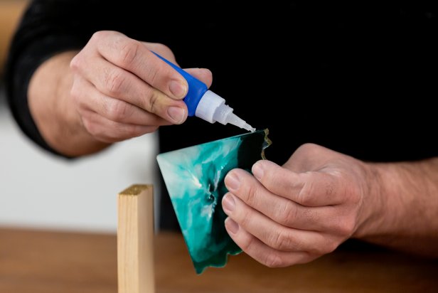 Add a small amount of super glue along the straight edges of the resin slice and adhere it to the inside of the wood. Hold firmly until the glue is dry. Repeat for the second piece.