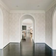 Open Foyer With Three Archways and Patterned Wallpaper