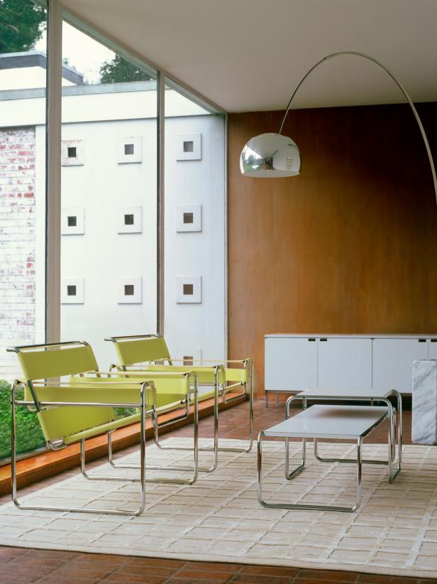 Two bright yellow Wassily lounge chairs beside a plate-glass window.