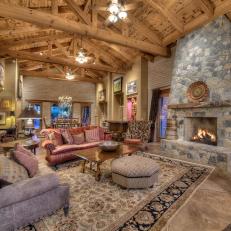 Expansive Living Room With Massive Exposed-Beam Ceiling and Stone Fireplace