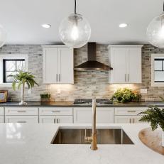 Spacious Kitchen Island Featuring Glass Pendant Lights
