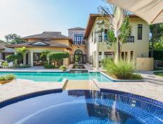 A Villa Sits Near a Swimming Pool and a Hot Tub Amongst Tropical Foliage
