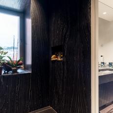 Black Marble Shower Features a Window That Overlooks the City