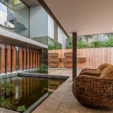 Stone Covered Patio Showcases a Modern Water Feature and a Sitting Area