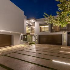 A Concrete Slab Driveway Leads to Two Modern Wood Garage Doors