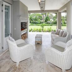 A Covered Patio Features Wicker Furniture and an Outdoor Fireplace