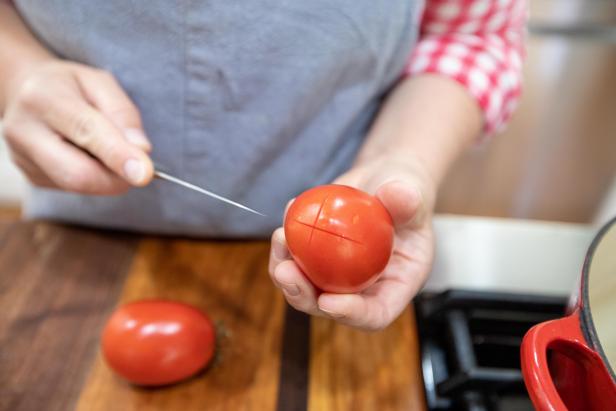 cutting an x in tomato before peeling