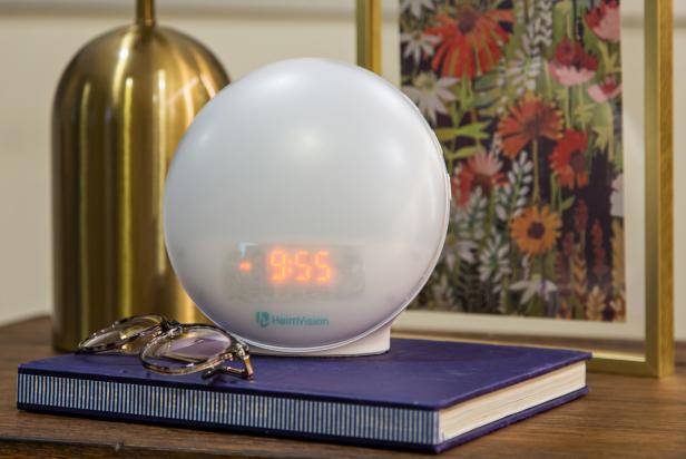 glasses and sunrise clock on nightstand