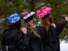 Three Women Taking Picture in Decorated Graduation Caps 