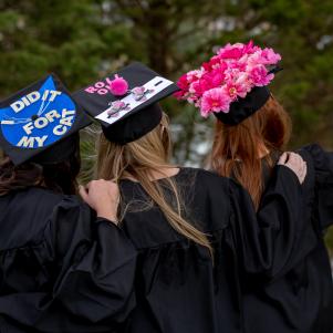 Three Women Taking Picture in Decorated Graduation Caps 