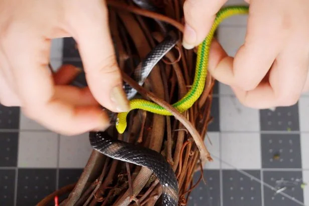 Weave in smaller rubber snakes the same way to fill in any gaps from the larger snakes. You may want to use needlenose pliers to grab the snakes and pull them through smaller gaps in the sticks.