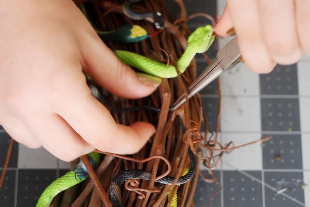 Weave in smaller rubber snakes the same way to fill in any gaps from the larger snakes. You may want to use needlenose pliers to grab the snakes and pull them through smaller gaps in the sticks.