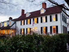 Classic Colonial Home Exterior, Light Glowing From 12 Front Windows